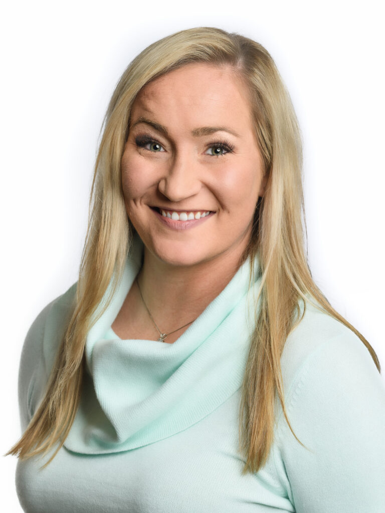 a woman with blonde hair wearing a light blue sweater